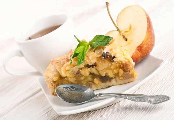 Apfelkuchen und frische Äpfel auf einem Holztisch — Stockfoto