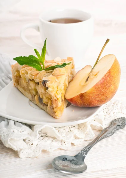 Apple pie and fresh apples on a wooden table — Stock Photo, Image