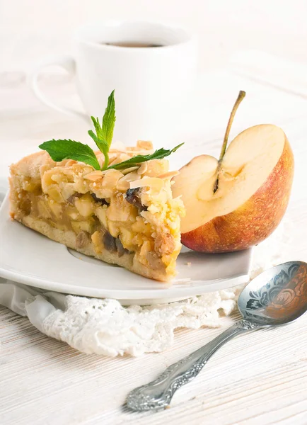 Apfelkuchen und frische Äpfel auf einem Holztisch — Stockfoto