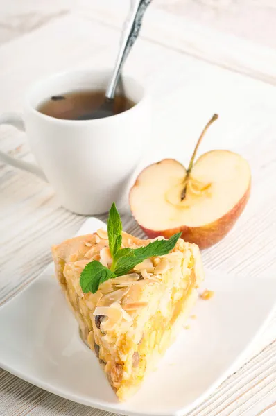 Яблочный пирог и свежие яблоки на деревянном столе — стоковое фото