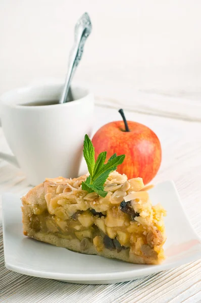 Apfelkuchen und frische Äpfel auf einem Holztisch — Stockfoto