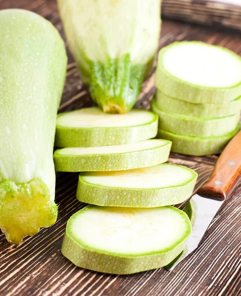 Green zucchini on an old wooden board — Stock Photo, Image