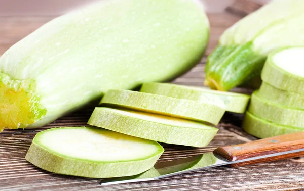 Calabacín verde sobre una vieja tabla de madera — Foto de Stock