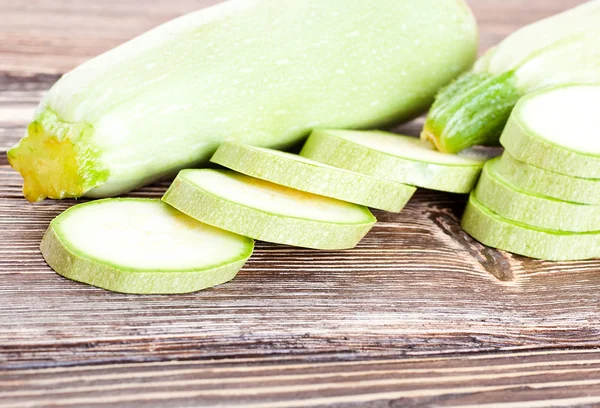 Green zucchini on an old wooden board — Stock Photo, Image