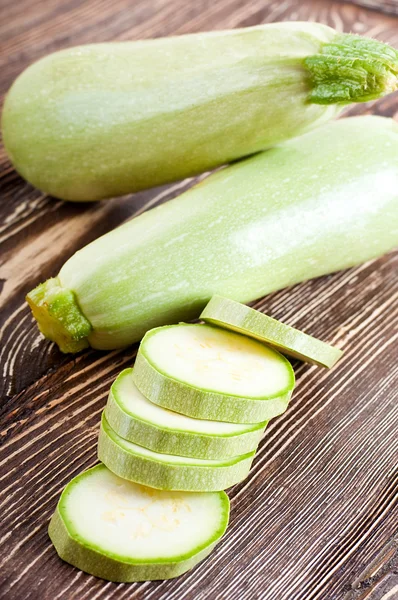 Green zucchini on an old wooden board — Stock Photo, Image