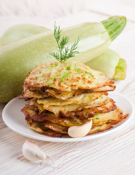 Green zucchini pancakes on a wooden old board — Stock Photo, Image
