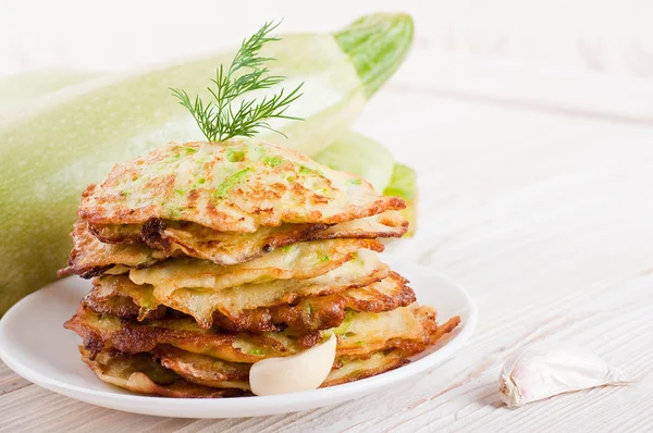 Green zucchini pancakes on a wooden old board — Stock Photo, Image