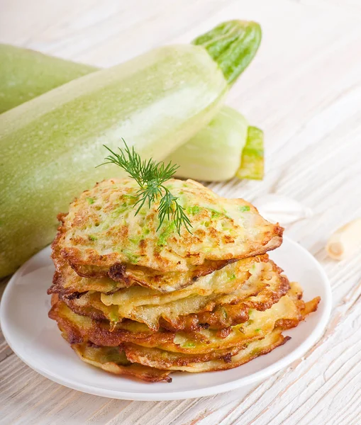 Green zucchini pancakes on a wooden old board — Stock Photo, Image