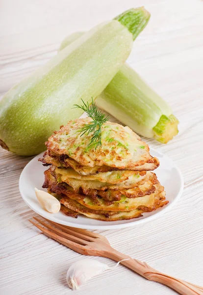 Green zucchini pancakes on a wooden old board — Stock Photo, Image