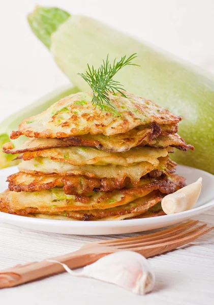 Crêpes de courgettes vertes sur une vieille planche en bois — Photo