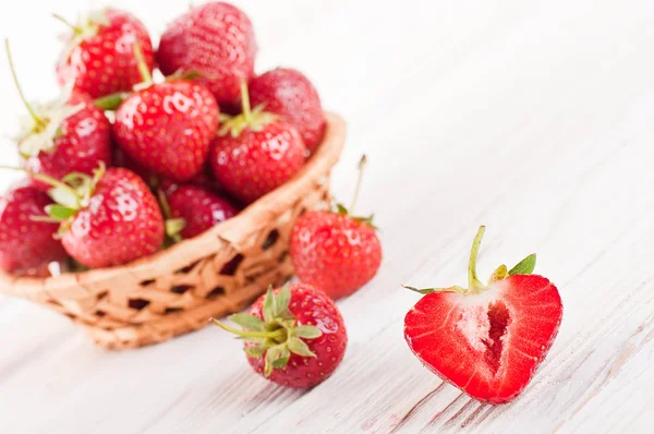在白板上的柳条篮中成熟的草莓 — 图库照片