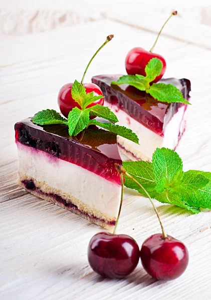 Cherry cheesecake med te på ett träbord — Stockfoto