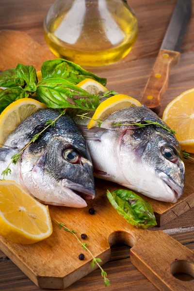 Dorado-Fisch mit Zitrone und Gewürzen auf einem Holzbrett — Stockfoto