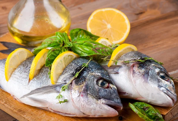Dorado fish with lemon and spices on a wooden board — Stock Photo, Image