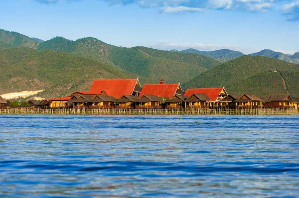 Oude huizen en hun weerspiegeling in het water op het Inlemeer, myanmar — Stockfoto