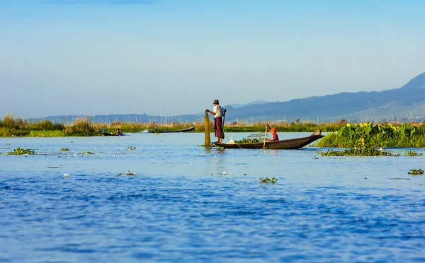 Fiskare och deras spegelbild i vattnet på sjön inle, myanmar — Stockfoto