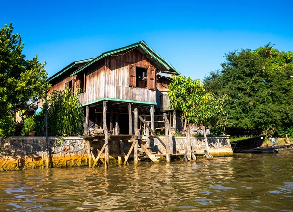 Oude huizen en hun weerspiegeling in het water op het Inlemeer, myanmar — Stockfoto