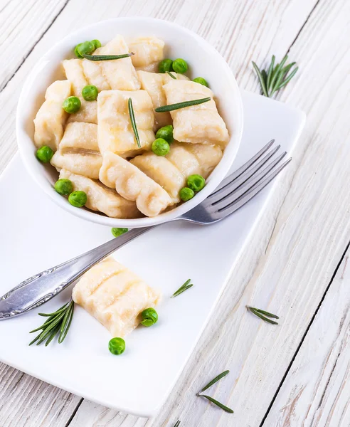 Cheese gnocchi with peas and rosemary — Stock Photo, Image