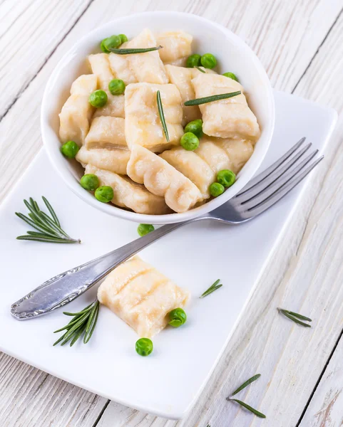 Cheese gnocchi with peas and rosemary — Stock Photo, Image