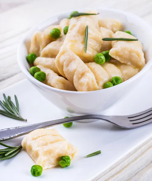 Cheese gnocchi with peas and rosemary — Stock Photo, Image