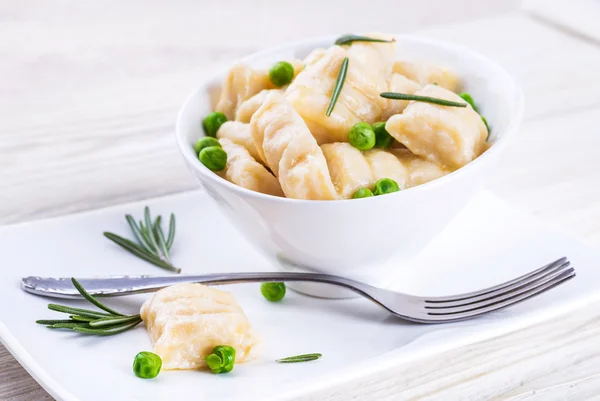 Cheese gnocchi with peas and rosemary — Stock Photo, Image