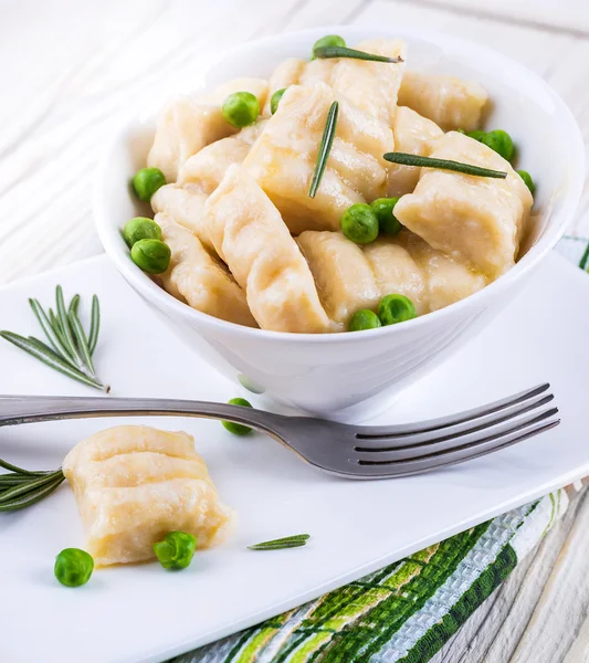 Cheese gnocchi with peas and rosemary — Stock Photo, Image