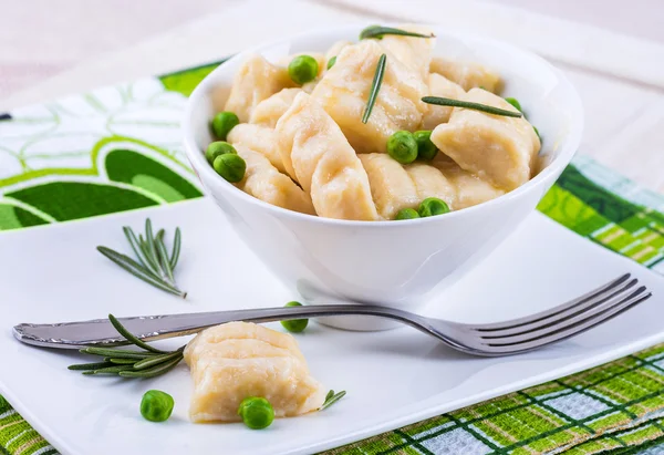 Cheese gnocchi with peas and rosemary — Stock Photo, Image