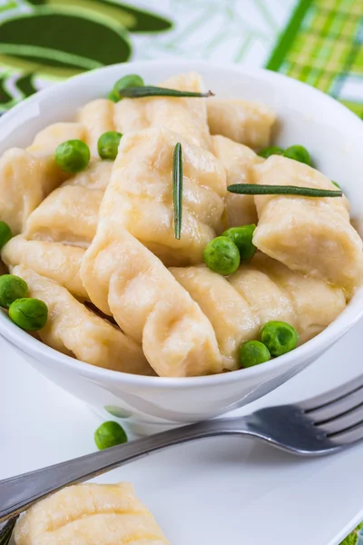 Cheese gnocchi with peas and rosemary — Stock Photo, Image