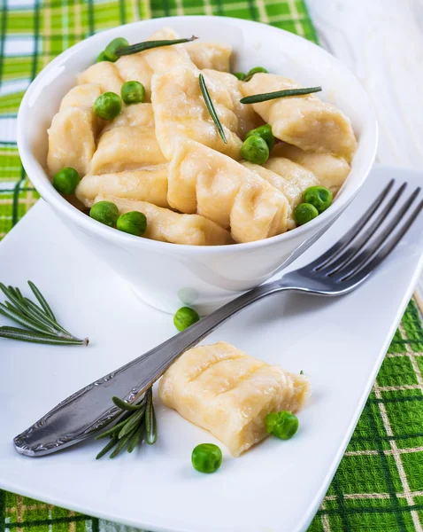 Cheese gnocchi with peas and rosemary — Stock Photo, Image