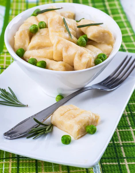 Cheese gnocchi with peas and rosemary — Stock Photo, Image