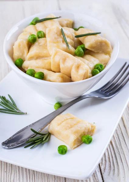 Cheese gnocchi with peas and rosemary — Stock Photo, Image