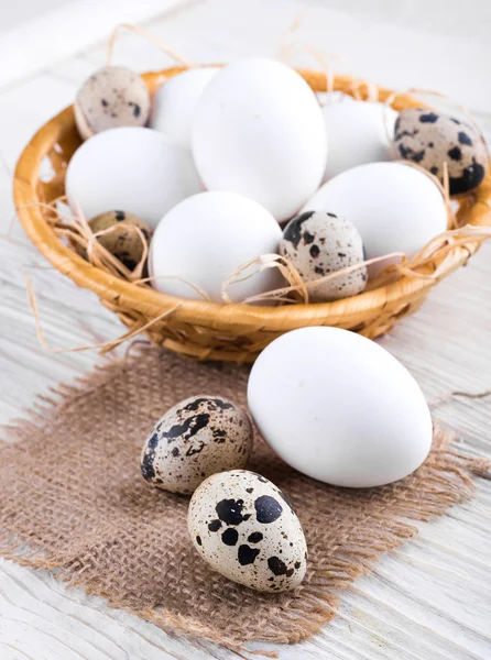 Quail and chicken eggs in a basket — Stock Photo, Image