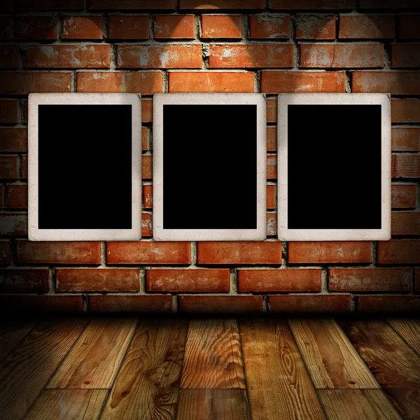 Empty frames in a room against a brick wall — Stock Photo, Image