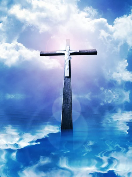 Крест в солнечных лучах против облачного неба — стоковое фото