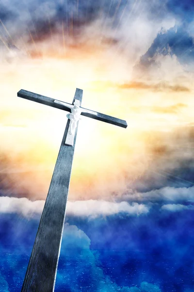 Хрест на сонячних променях проти хмарного неба — стокове фото