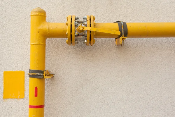 Желтая газовая труба с краном и механизмом — стоковое фото