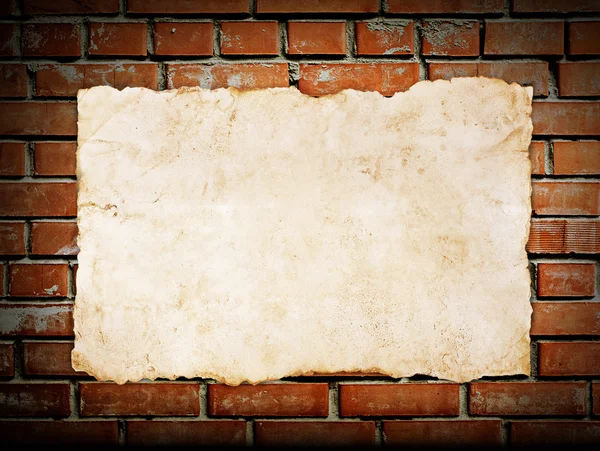 Old paper on brickwall — Stock Photo, Image