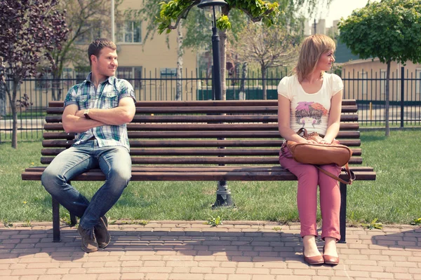 Young couple at quarrel on bench in park — Stock Photo, Image