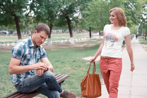 Man waiting for woman on bench in park — Stock Photo, Image