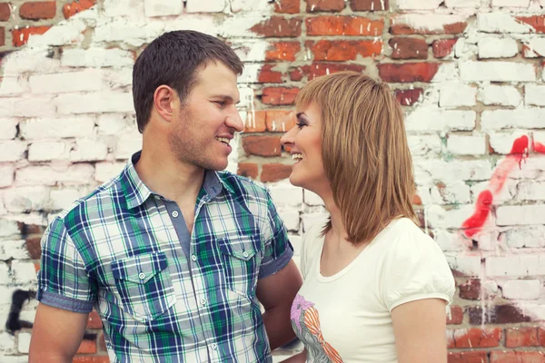 Jeune couple contre mur graffiti — Photo