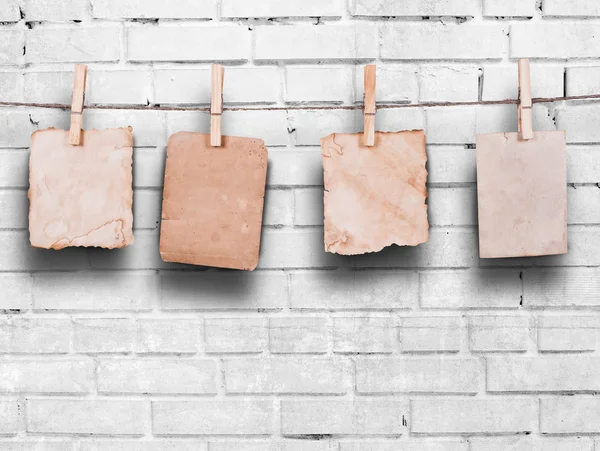 Photo frames with pins on rope over old aged brick wall — Stock Photo, Image