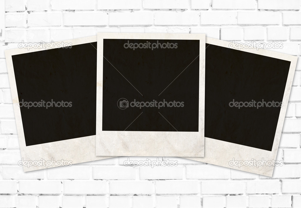 three photo frames against white brick wall