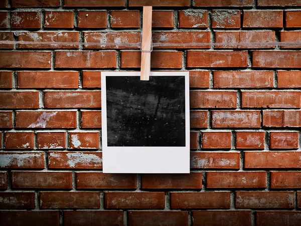 Fotoframe met pinnen op touw over oude leeftijd bakstenen muur — Stockfoto