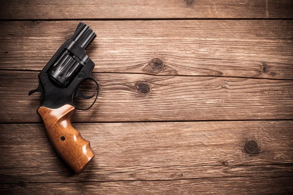 Pistola em um fundo de madeira — Fotografia de Stock