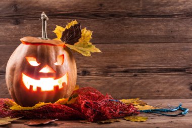 Jack-o-lantern ahşap zemin üzerinde yaprakları ile
