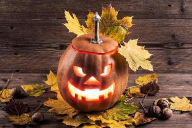 Jack-o-lantern ahşap zemin üzerinde yaprakları ile