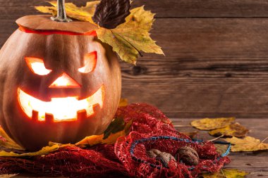 Jack-o-lantern ahşap zemin üzerinde yaprakları ile