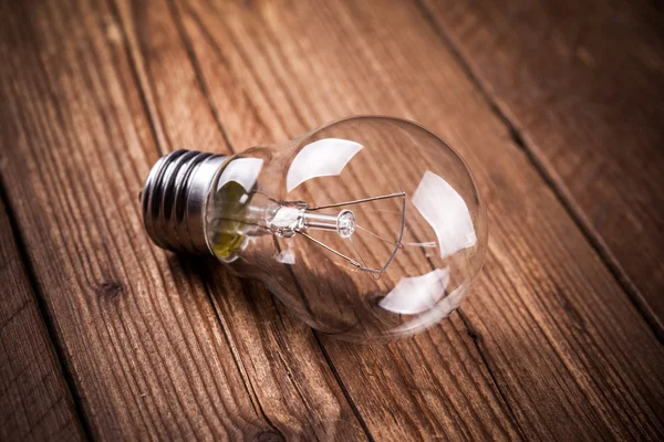 Bulb on the brown wooden background — Stock Photo, Image