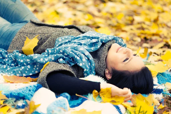 Giovane donna posa in foglie di autunno — Foto Stock