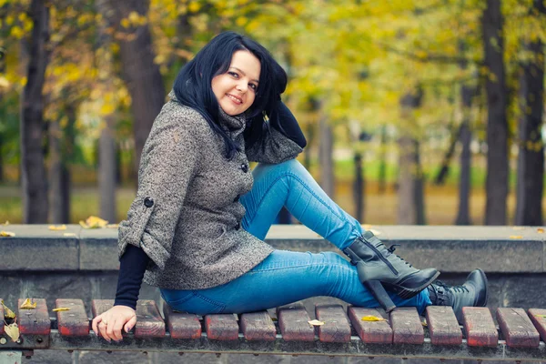 Mädchen sitzt auf Bank — Stockfoto